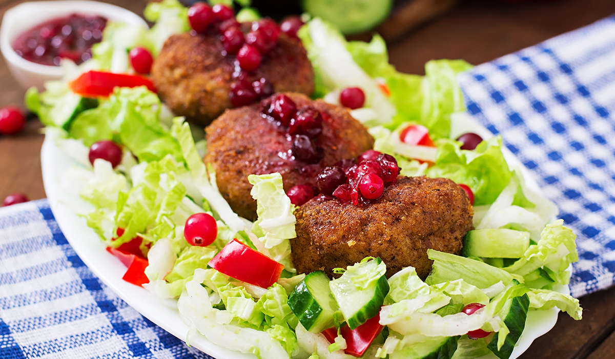 juicy-meat-cutlets-with-cranberry-sauce-salad-wooden-table-rustic-style